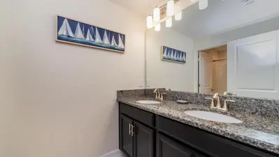 a bathroom with two sinks and a mirror at Gatsby Escape: Private Pool Near Disney & Resorts in Kissimmee