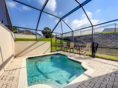 a swimming pool in a glass house with a table and chairs at Krista's Tropical Escape: Resort Stay Near Disney in Kissimmee