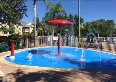 a small pool with a fountain in a park at Krista's Tropical Escape: Resort Stay Near Disney in Kissimmee