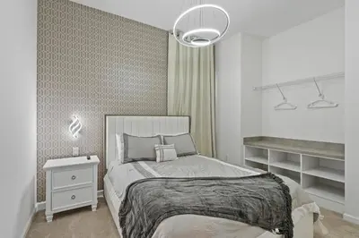a white bedroom with a bed and a night stand at Paradiso Grande Resort 9Bedroom Vacation Home 6210 in Orlando