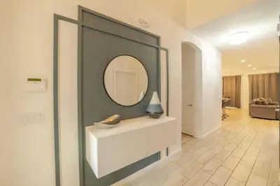 a living room with a mirror and a white dresser at Mario Bros Game room 8BD Pool Movie Room 2622 in Kissimmee