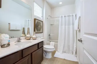 a white bathroom with a toilet and a sink at Mario Bros Game room 8BD Pool Movie Room 2622 in Kissimmee