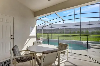 a room with a table and chairs and a large window at Luxury Pool Home 3 Miles from Disney & More! in Kissimmee