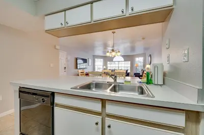 a kitchen with a sink and a living room at 7 Mi to Disney Condo with Pool and Hot Tub Access! in Kissimmee