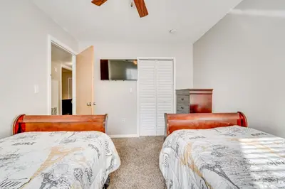 two beds in a bedroom with white walls at 7 Mi to Disney Condo with Pool and Hot Tub Access! in Kissimmee