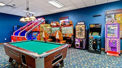 a room with a pool table and arcade games at CPR8951 in Kissimmee