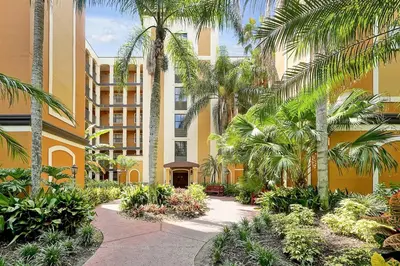 a courtyard with palm trees in front of a building at 12538 INTERNATIONAL DRIVE #C303 ORLANDO 2BED in Orlando