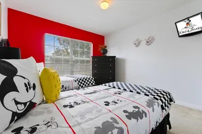 a bedroom with a black and white bed and a red wall at MNL2678 in Orlando