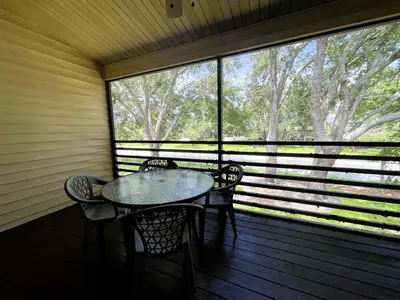 a table and chairs on a porch with a large window at 2950 COTTAGE GROVE COURT ORLANDO 3BED in Orlando