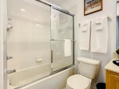 a bathroom with a toilet and a glass shower at Luxury Townhome Near Disney w/ Resort Amenities in Orlando