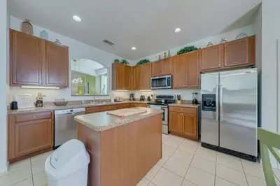 a large kitchen with wooden cabinets and stainless steel appliances at 5 Bedroom private pool home in Veranda Palms in Kissimmee