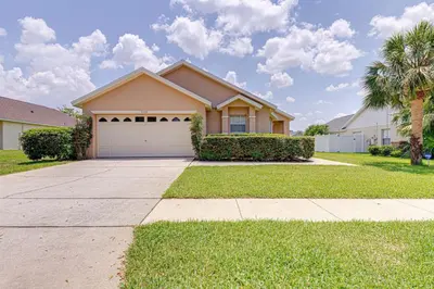 a house with a garage and palm trees at Pool home close to Golfing and Theme parks in Orlando