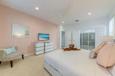 a bedroom with a bed and a chair and a television at 6 Bed villa close to disney in Kissimmee