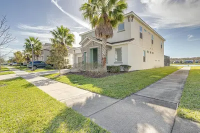 a white house with palm trees and a sidewalk at 6 Bed villa close to disney in Kissimmee