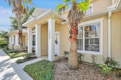 a palm tree in front of a house at Magical serenity 3 bedroom pool home in Orlando