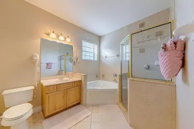a bathroom with a toilet and a shower and a sink at Luxury Pool Home - Disney View in Orlando