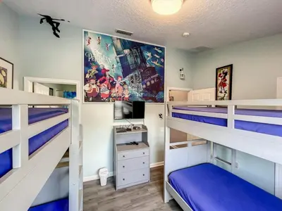 a bedroom with two bunk beds with blue sheets at Mickey's Play House: Family Fun & Comfort in Kissimmee