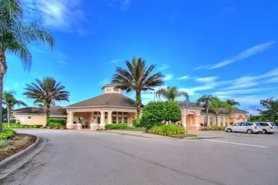 a large house with palm trees on a street at Mickey's Play House: Family Fun & Comfort in Kissimmee