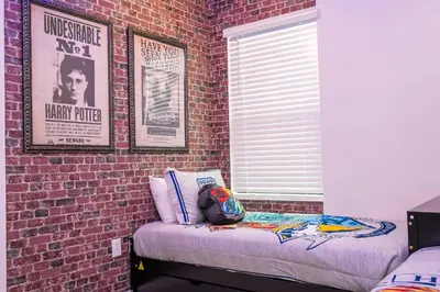 a stuffed animal sitting on a bed against a brick wall at 5761 HS - Spacious Luxury Villa in Paradiso Grande in Orlando