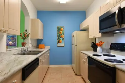 a kitchen with a sink and a refrigerator at Orangebaum Condo: 8 Min to Disney + Resort Perks in Kissimmee