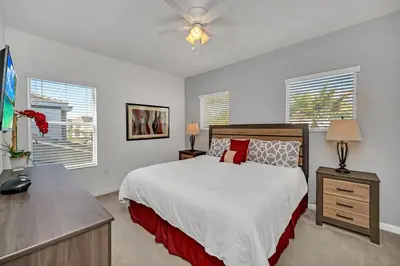 a bedroom with a bed and a ceiling fan at DREAM VILLA 6bd, all en-suite, pool, spa, grill, theatre in Kissimmee