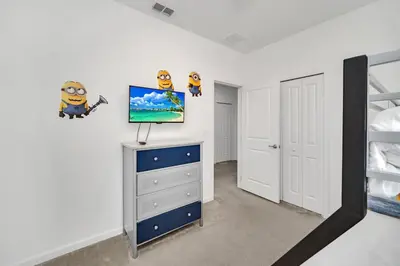 a bedroom with a bed and a tv on a dresser at DREAM VILLA 6bd, all en-suite, pool, spa, grill, theatre in Kissimmee