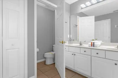 a white bathroom with a sink and a toilet at Spacious 7-Bedroom Home at Bella Vida Resort with Conservation View in Kissimmee