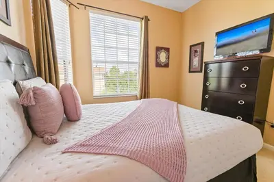 a bedroom with a bed with a television and a dresser at ALM2813-403 in Orlando
