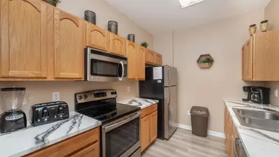 a kitchen with wooden cabinets and black appliances at ALM2821-204 in Orlando