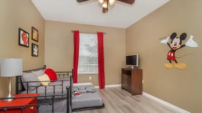 a bedroom with a bed with a mickey mouse on the wall at ALM2821-204 in Orlando