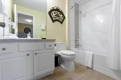 a white bathroom with a tub and a toilet and a sink at DVL2638 in Orlando