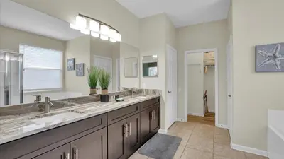 a bathroom with two sinks and a large mirror at FP8176 Windsor Palms Resort Vacation Home in Kissimmee