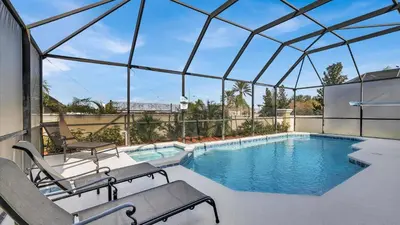a swimming pool with chairs and a large glass roof at FP8176 Windsor Palms Resort Vacation Home in Kissimmee