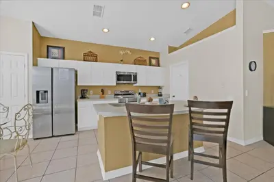 a kitchen with two chairs and a counter top at FP8190 Windsor Palms Resort Vacation Home in Kissimmee