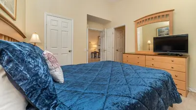 a bedroom with a blue bed and a television at FP8190 Windsor Palms Resort Vacation Home in Kissimmee
