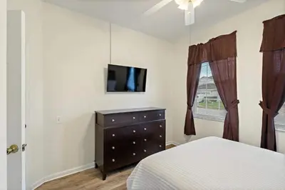 a bedroom with a bed and a dresser and a tv at FP8104 Windsor Palms Resort Vacation Home in Kissimmee
