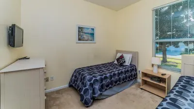 a bedroom with a bed and a tv and a window at FP8147 Windsor Palms Resort Vacation Home in Kissimmee