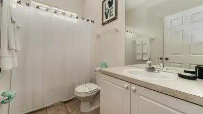 a white bathroom with a toilet and a sink at FP8150 Windsor Palms Resort Vacation Home in Kissimmee