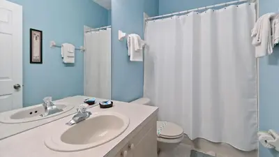 a bathroom with a sink and a white shower curtain at FP8159 Windsor Palms Resort Vacation Home in Kissimmee