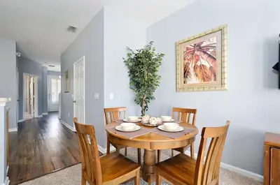 a dining room with a wooden table and chairs at Luxury 3-bdr house with pool next to Disney in Orlando