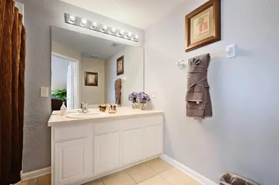 a bathroom with a white sink and a mirror at Luxury 3-bdr house with pool next to Disney in Orlando