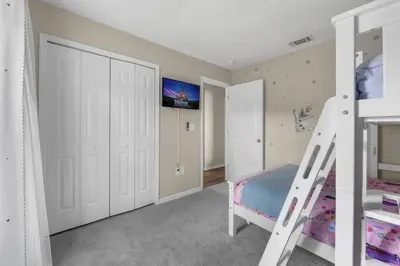 a white bedroom with a bunk bed and a ladder at New Listing Pool and Game Room 4BR in Orlando