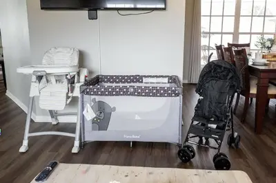 a room with a crib with a table and a baby stroller at New Listing Pool and Game Room 4BR in Orlando