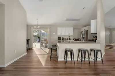 a kitchen with a white counter and stools at New Listing Pool and Game Room 4BR in Orlando