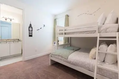 a bedroom with two bunk beds and a bathroom at Contemporary Disney VacationHome in Orlando