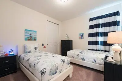 a bedroom with two beds and a dresser at Contemporary Disney VacationHome in Orlando