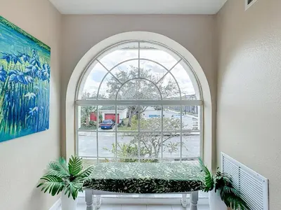 an arch window with a bench in front of it at Stunning 5BR 5Bath Home, Pool, Spa, By Disney in Kissimmee
