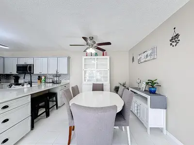 a kitchen with a white table and a ceiling fan at Stunning 5BR 5Bath Home, Pool, Spa, By Disney in Kissimmee
