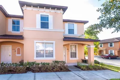 a pink house with a driveway at Spacious Regal Oaks Retreat - Steps to the Pool in Orlando