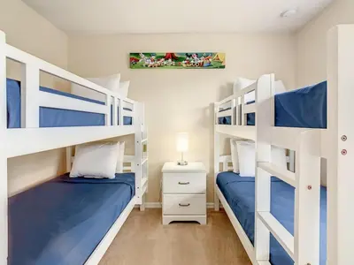 two bunk beds in a bedroom with blue and white at Spacious Regal Oaks Townhome by Disney in Orlando